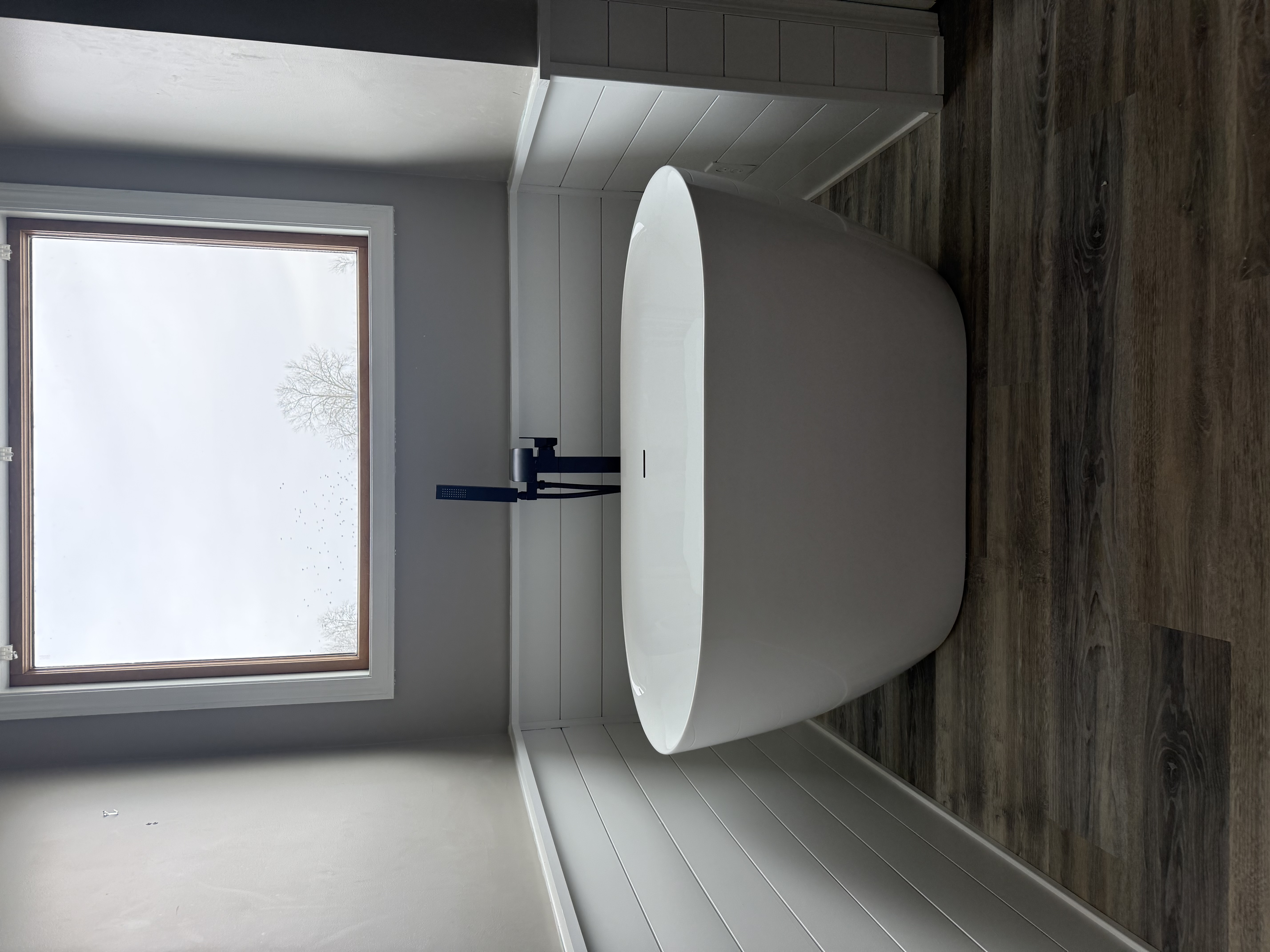 Freestanding soaking tub with shiplap accent wall