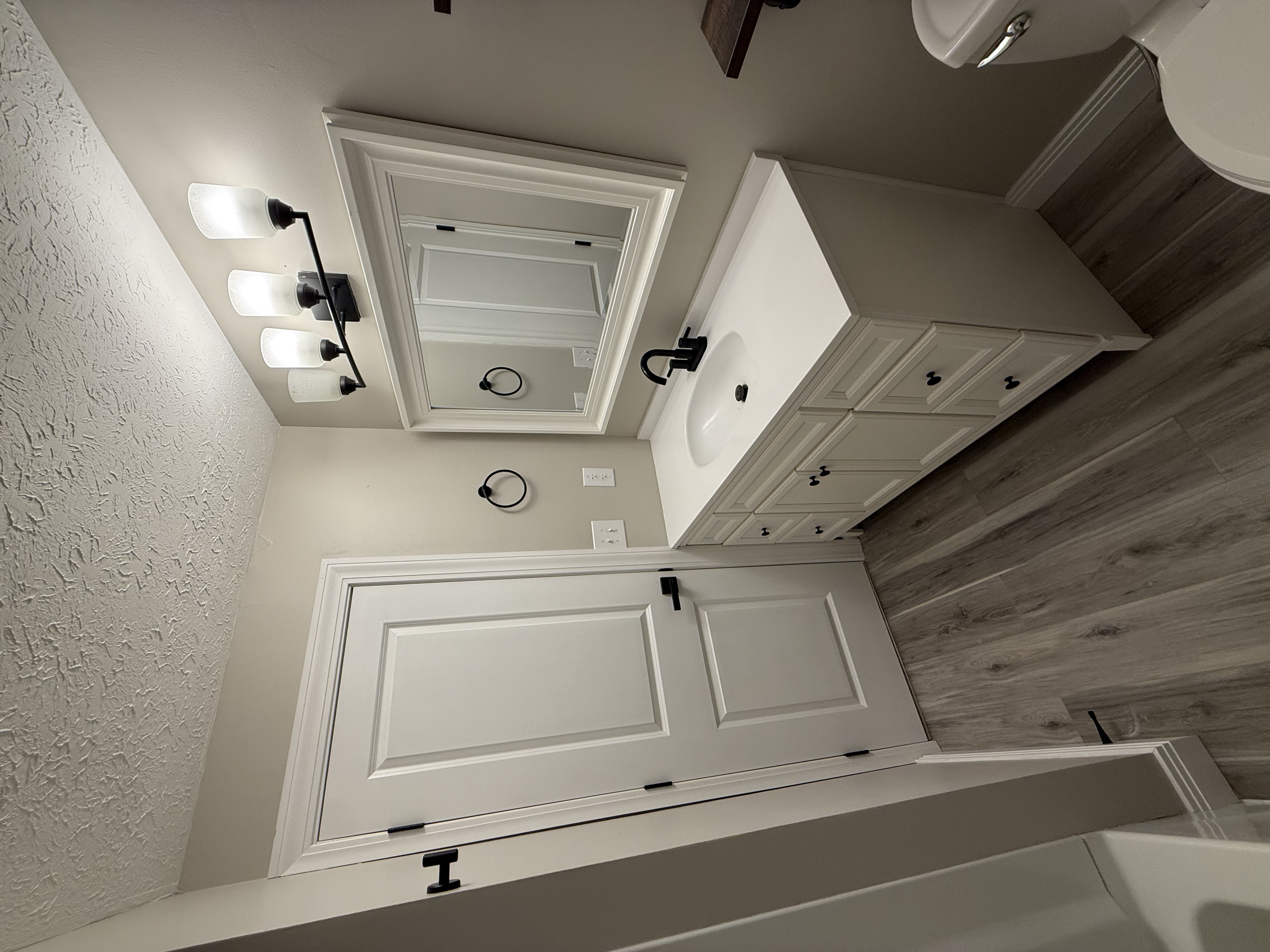 White vanity with black hardware and board-and-batten accent wall
