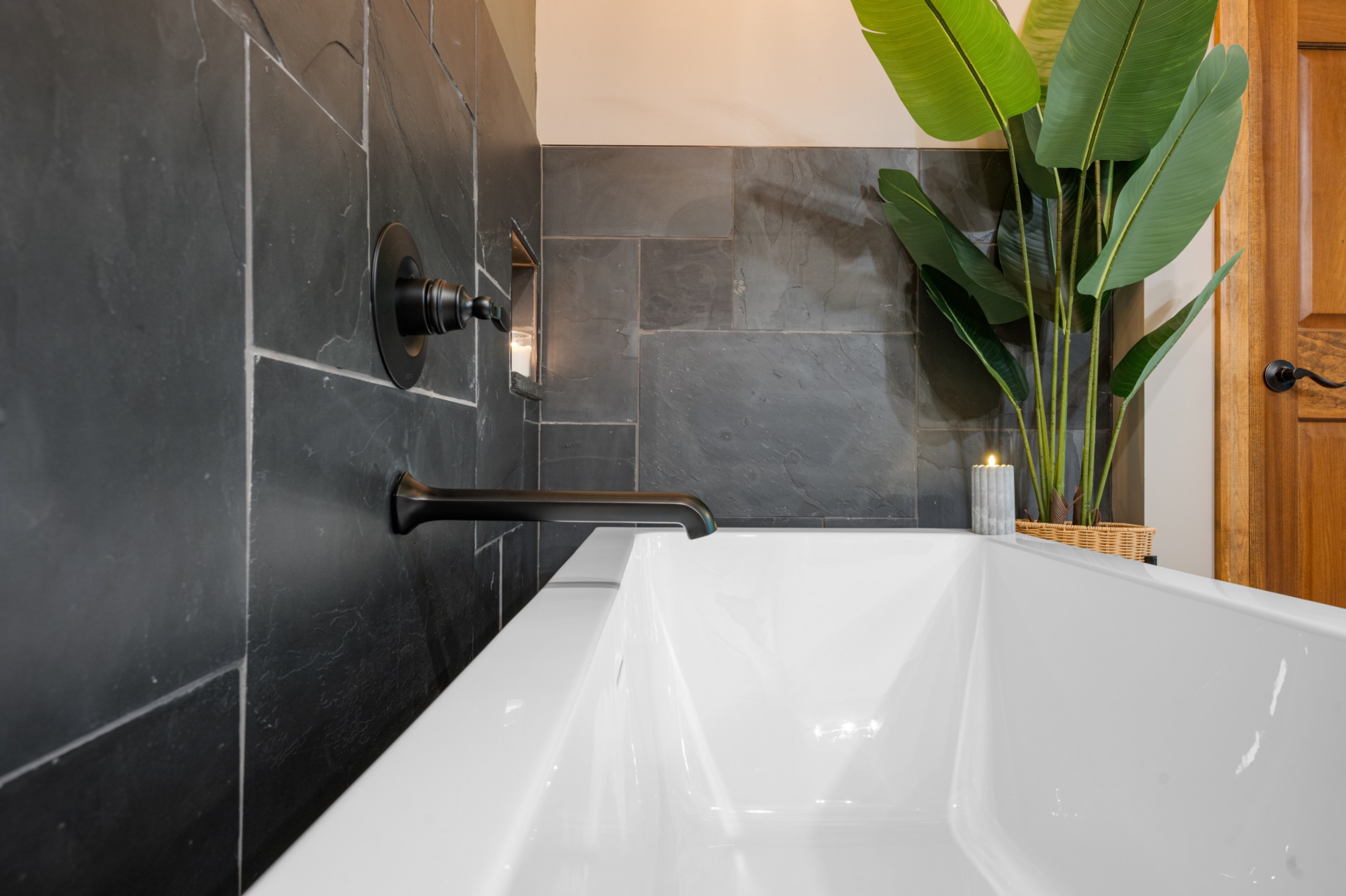 Freestanding tub detail with wall-mount faucet and slate surround